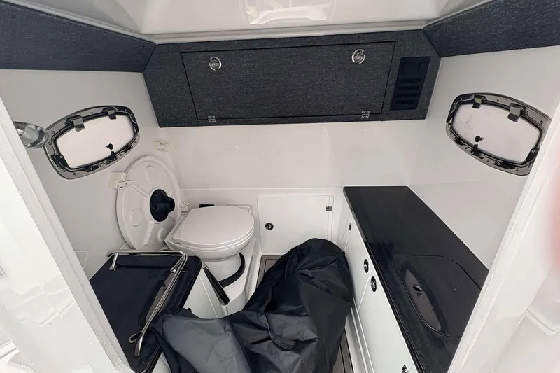 Slide: The Image of 2026 Monterey 27 Elite boat interior with toilet, sink, and storage cabinets. - 11