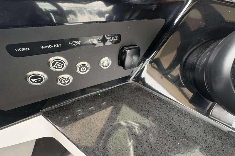 Slide: The Image of Control panel of 2026 Monterey 27 Elite boat with various switches and buttons. - 13
