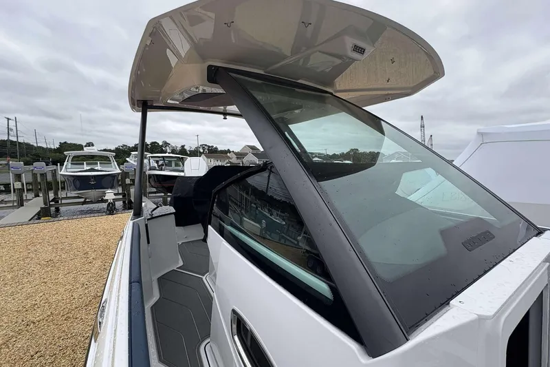 Slide: The Image of 2026 Monterey 27 Elite boat with sleek design, docked at marina under cloudy sky. - 3