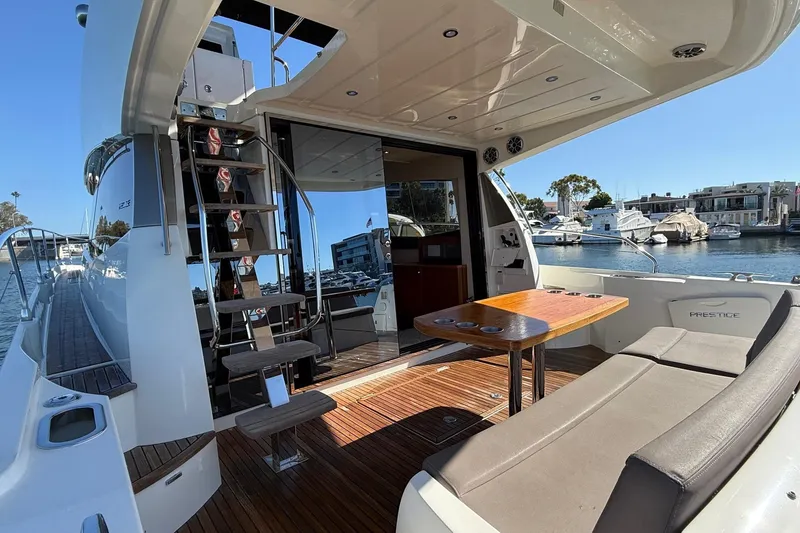 Slide: The Image of 2016 Prestige 500 yacht interior with seating, table, and marina view. - 10