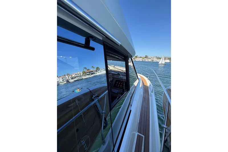 Slide: The Image of 2016 Prestige 500 yacht cruising on a sunny day with scenic waterfront views. - 14