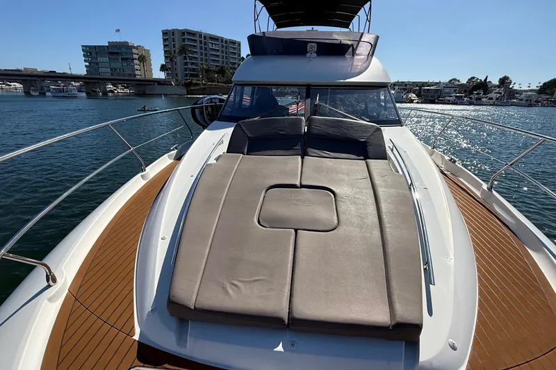 Slide: The Image of 2016 Prestige 500 yacht with sun deck, docked in a marina under clear skies. - 16