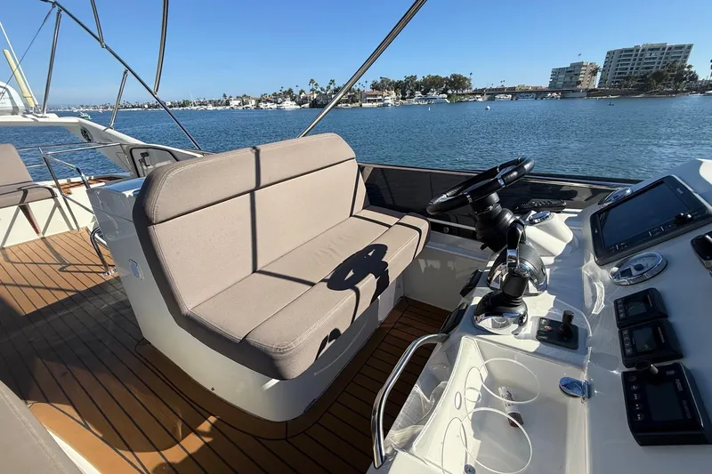Slide: The Image of Luxurious 2016 Prestige 500 yacht helm with plush seating and modern controls, overlooking serene waters. - 24