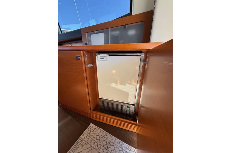 Slide: The Image of 2016 Prestige 500 yacht interior with built-in refrigerator and wooden cabinetry. - 26