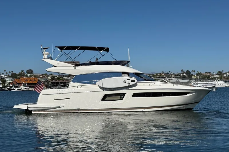 Slide: The Image of 2016 Prestige 500 yacht cruising in a sunny harbor, displaying sleek design and elegance. - 3