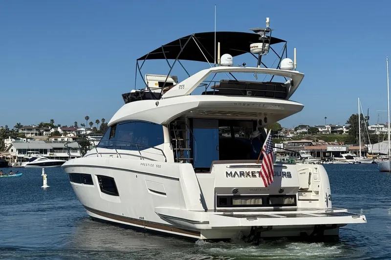 Slide: The Image of Luxury 2016 Prestige 500 yacht cruising in a scenic harbor setting. - 4