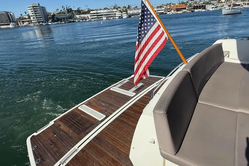 Slide: The Image of Luxury yacht deck with American flag, Prestige 500, 2016 model, docked in scenic marina. - 6