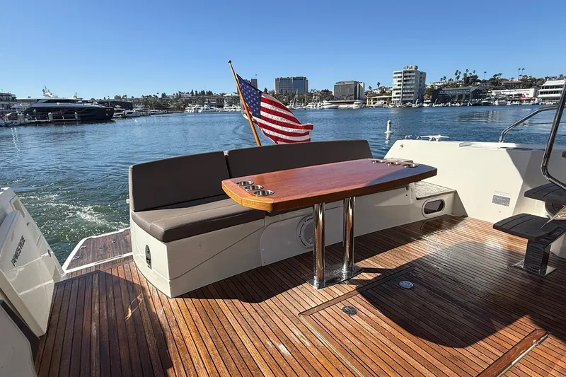 Slide: The Image of Luxury 2016 Prestige 500 yacht deck with seating, table, and American flag in marina. - 9