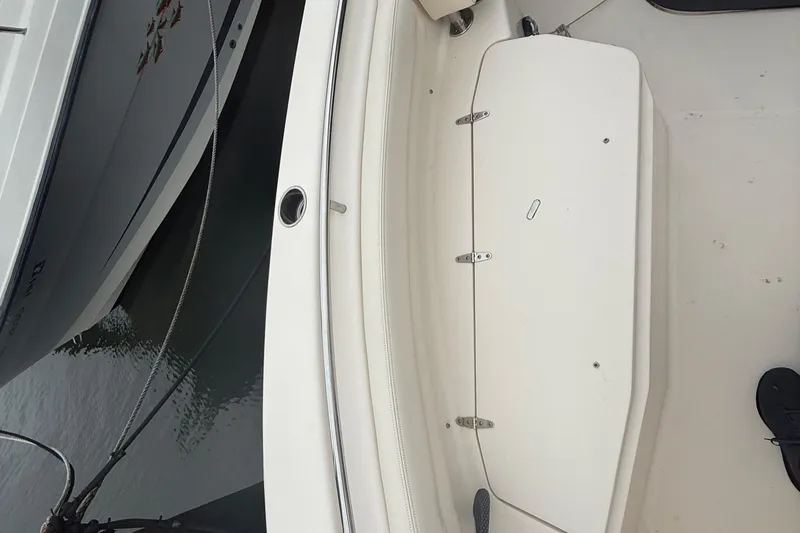 Slide: The Image of 2020 Grady-White Fisherman 257 boat deck with storage compartment, docked beside another vessel. - 16