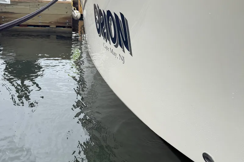 Slide: The Image of 2020 Grady-White Fisherman 257 boat docked, showing hull and water reflection. - 22