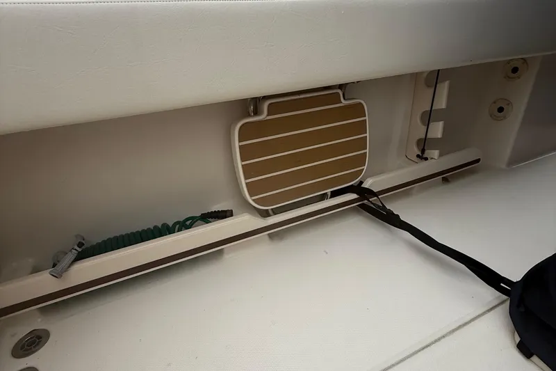 Slide: The Image of 2020 Grady-White Fisherman 257 boat interior storage compartment with coiled hose and accessories. - 31