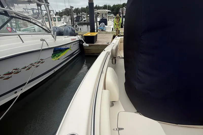 Slide: The Image of 2020 Grady-White Fisherman 257 docked beside a decorated boat in a marina. - 51