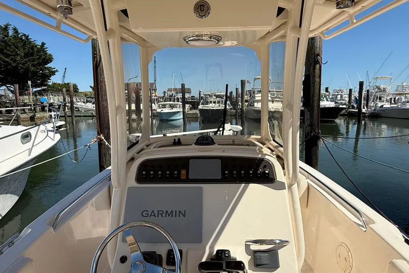 Slide: The Image of 2020 Grady-White Fisherman 257 boat dashboard with Garmin navigation, docked in a marina. - 56