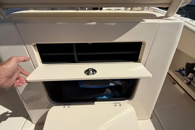 Slide: The Image of 2020 Grady-White Fisherman 257 boat storage compartment with open hatch and hand. - 60