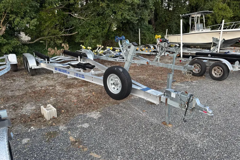 Slide: The Image of Boat trailer parked on gravel, with Grady-White Fisherman 257 in background, 2020 model. - 68