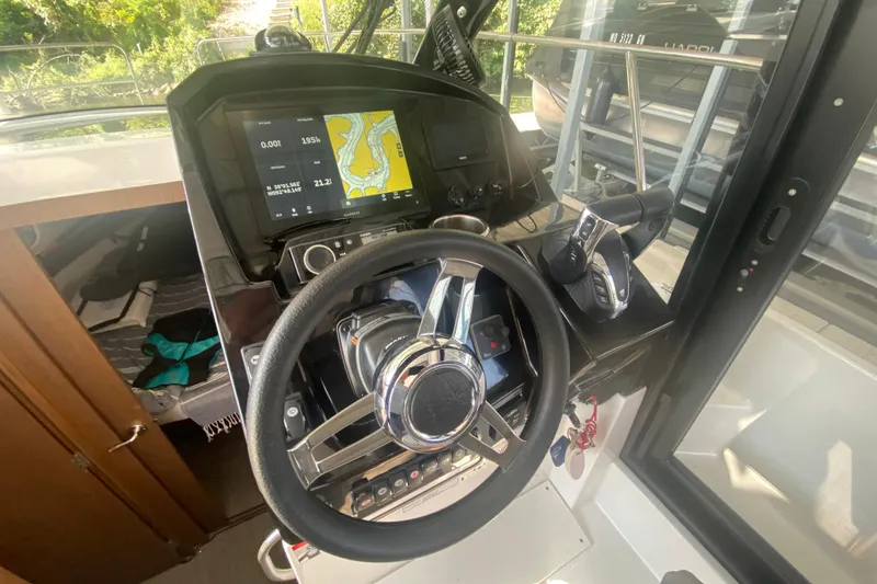 Slide: The Image of 2024 Jeanneau NC 895 helm with navigation display and steering wheel. - 26
