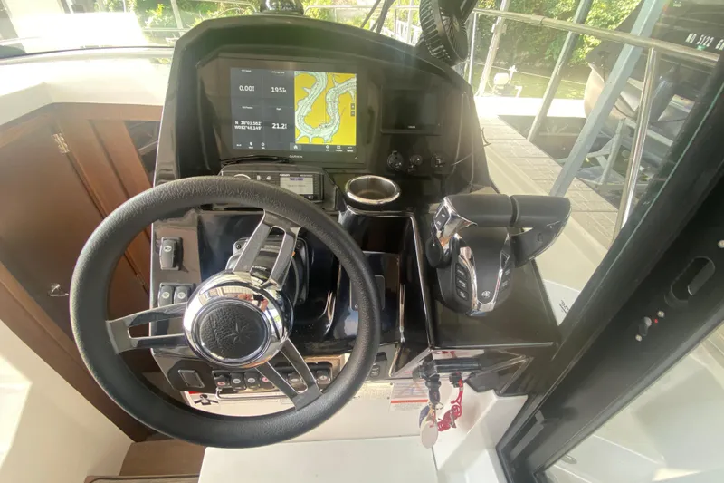 Slide: The Image of 2024 Jeanneau NC 895 helm with steering wheel, navigation display, and controls. - 27