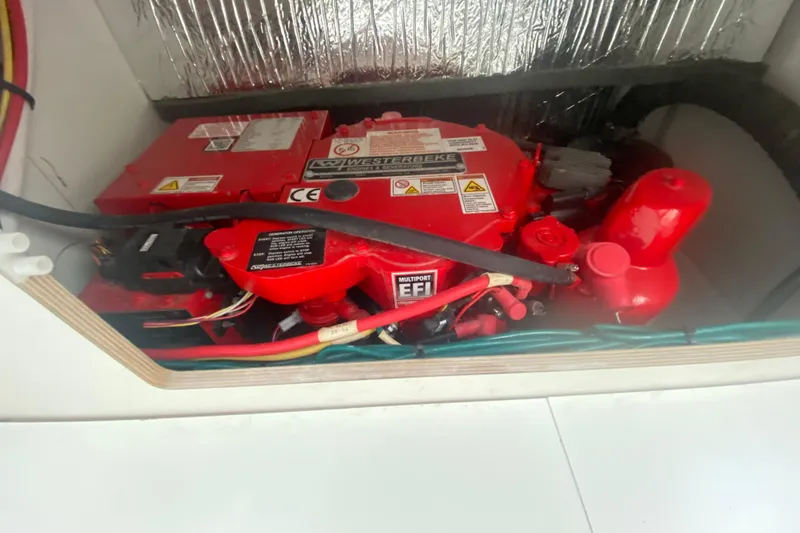 Slide: The Image of Engine compartment of 2024 Jeanneau NC 895 with red Westerbeke generator. - 29