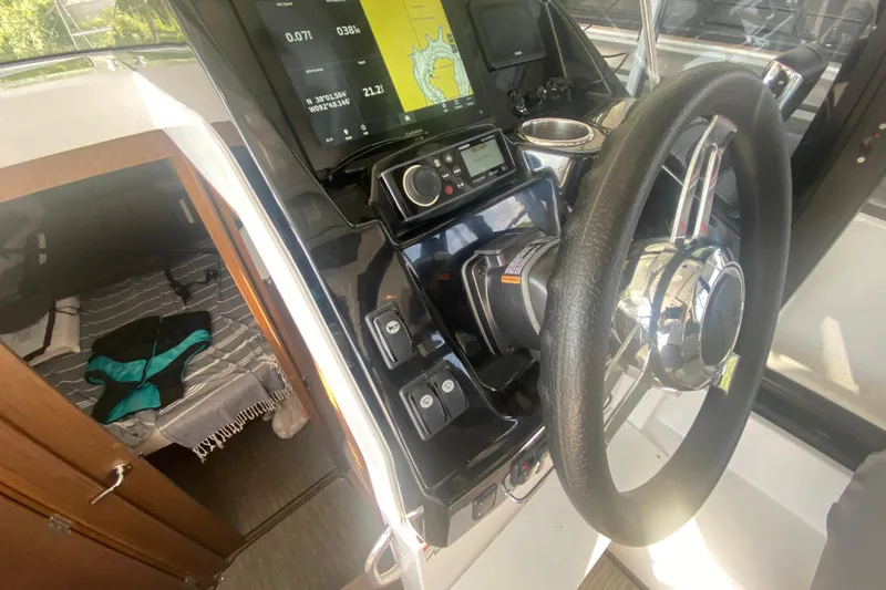Slide: The Image of 2024 Jeanneau NC 895 helm with navigation display and cabin view. - 32