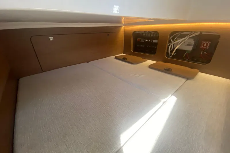 Slide: The Image of 2024 Jeanneau NC 895 cabin interior with control panel and cozy bedding. - 39