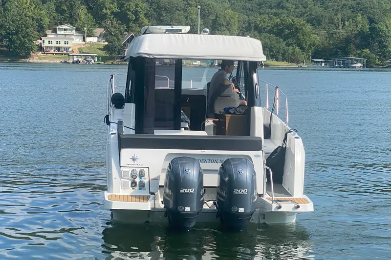 Slide: The Image of 2024 Jeanneau NC 895 boat on a lake with dual Yamaha engines. - 4