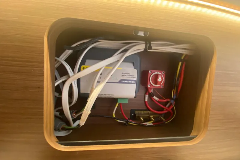 Slide: The Image of Electrical panel inside 2024 Jeanneau NC 895 boat, featuring battery charger and wiring. - 40