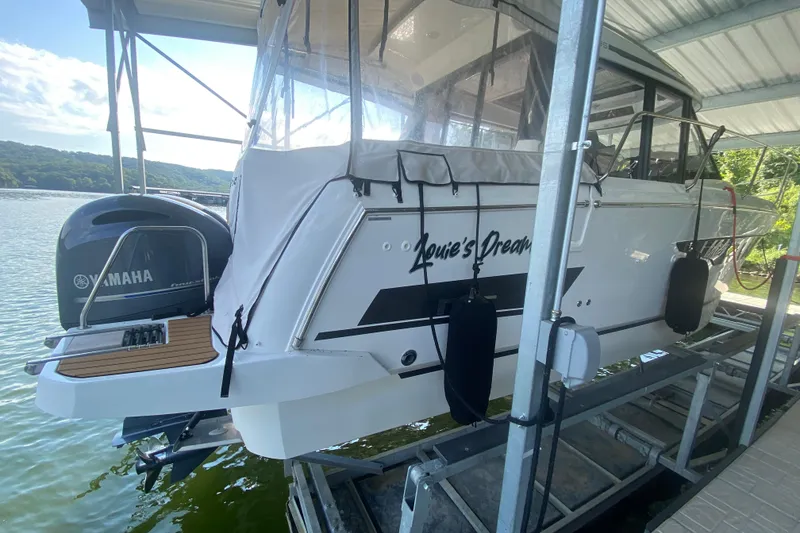 Slide: The Image of 2024 Jeanneau NC 895 boat with Yamaha engine docked on a lift. - 9