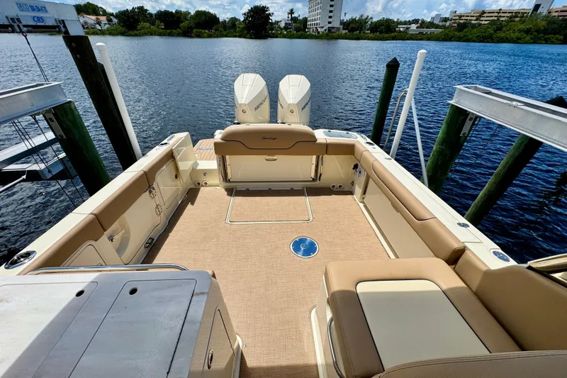 Slide: The Image of 2023 Chris-Craft Calypso 28 boat interior with seating, docked by the water. - 12