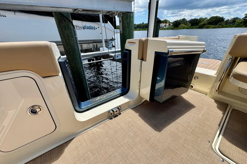 Slide: The Image of 2023 Chris-Craft Calypso 28 boat interior with open door, showcasing water view. - 14