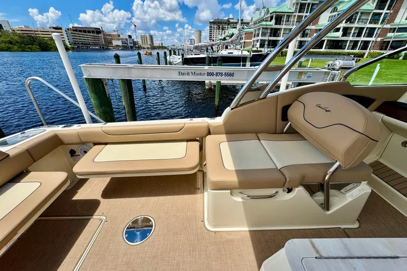 Slide: The Image of 2023 Chris-Craft Calypso 28 boat interior with tan seating and waterfront view. - 18