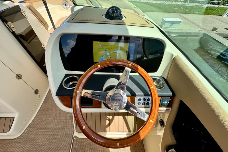 Slide: The Image of 2023 Chris-Craft Calypso 28 helm with wooden steering wheel and navigation display. - 20