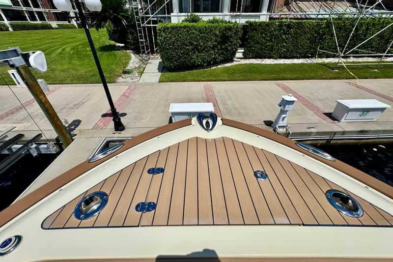 Slide: The Image of 2023 Chris-Craft Calypso 28 boat docked, showcasing elegant wooden deck design. - 25
