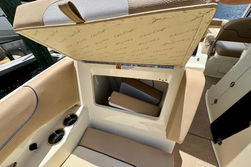 Slide: The Image of 2023 Chris-Craft Calypso 28 boat interior storage compartment with cushioned seating. - 30