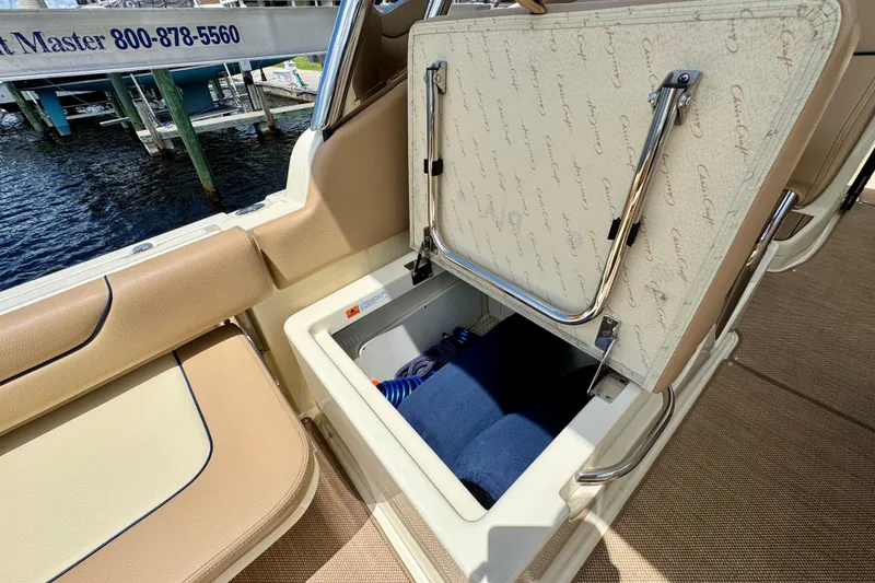 Slide: The Image of 2023 Chris-Craft Calypso 28 boat storage compartment with open lid, showcasing interior space. - 31