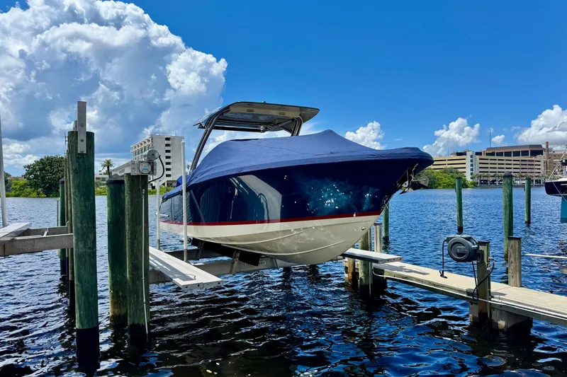 Slide: The Image of 2023 Chris-Craft Calypso 28 boat docked, covered, under a bright blue sky. - 35
