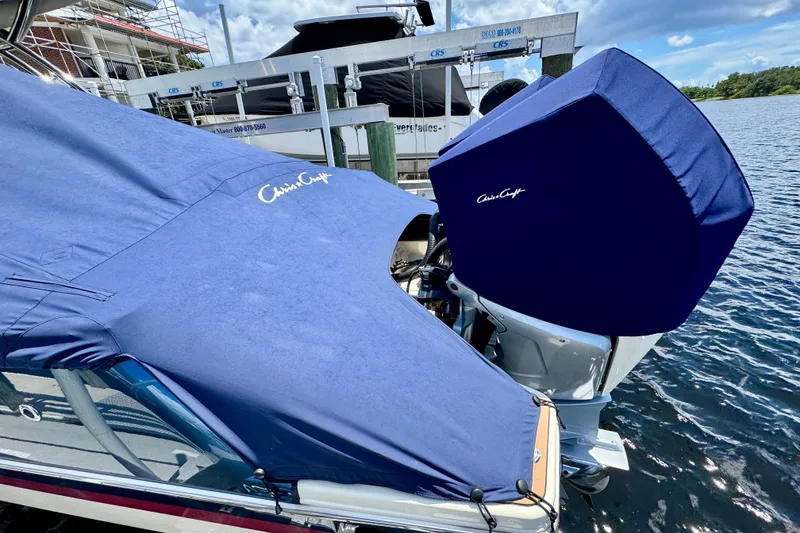 Slide: The Image of 2023 Chris-Craft Calypso 28 boat with blue covers docked by the water. - 36