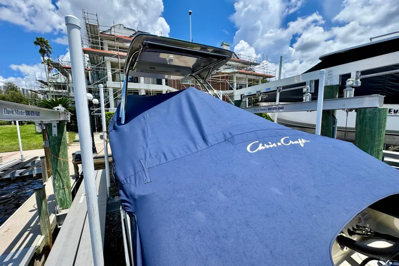 Slide: The Image of 2023 Chris-Craft Calypso 28 covered at dock, blue cover, sunny day, construction background. - 37