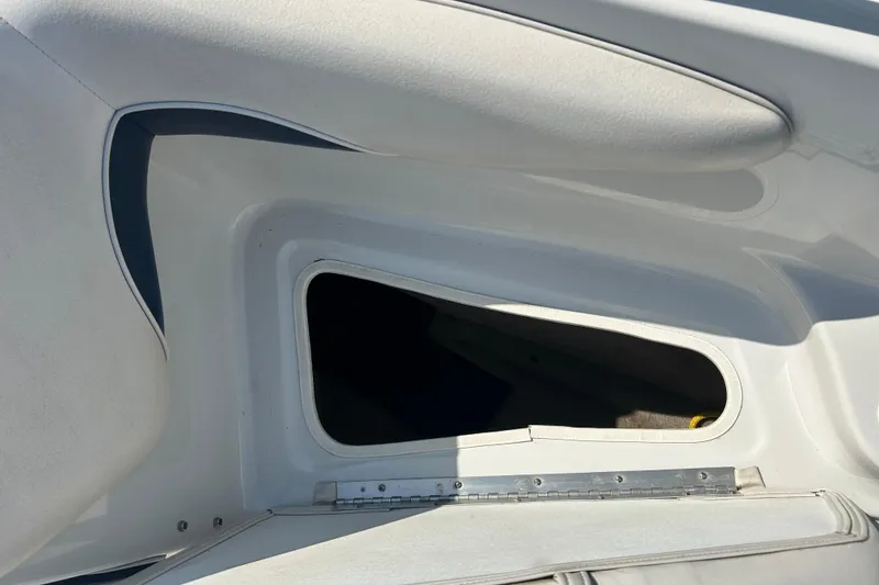 Slide: The Image of 2003 Crownline 192 BR boat storage compartment with open hatch, showcasing interior space. - 12