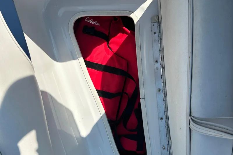 Slide: The Image of Red life jacket stored in a compartment of a 2003 Crownline 192 BR boat. - 13