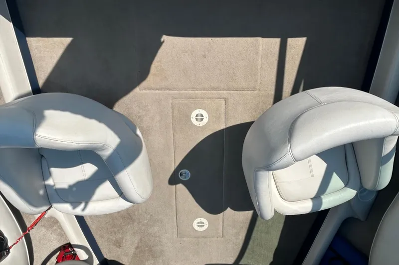 Slide: The Image of 2003 Crownline 192 BR boat interior with two white seats and carpeted floor. - 14