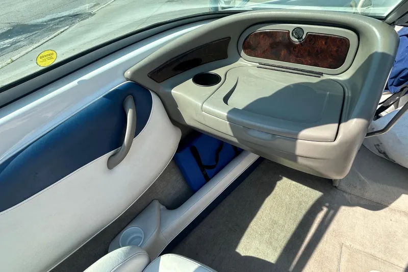 Slide: The Image of 2003 Crownline 192 BR boat interior with glove compartment and cup holder. - 15
