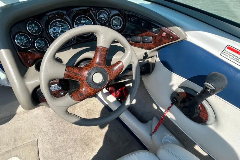 Slide: The Image of 2003 Crownline 192 BR boat dashboard with wood accents and steering wheel. - 16