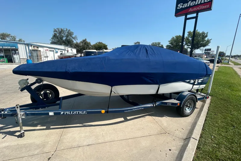Slide: The Image of 2003 Crownline 192 BR boat on trailer, covered with blue tarp, parked outdoors. - 4