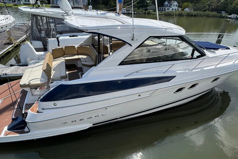 The Image of 2010 Regal 44 Sport Coupe yacht docked, featuring sleek design and spacious seating area. - 1