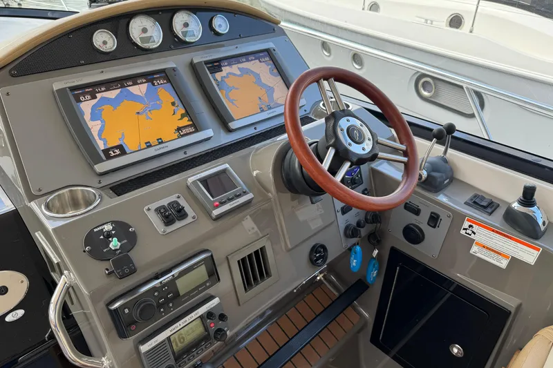 Slide: The Image of Control panel of a 2010 Regal 44 Sport Coupe with navigation screens and steering wheel. - 11