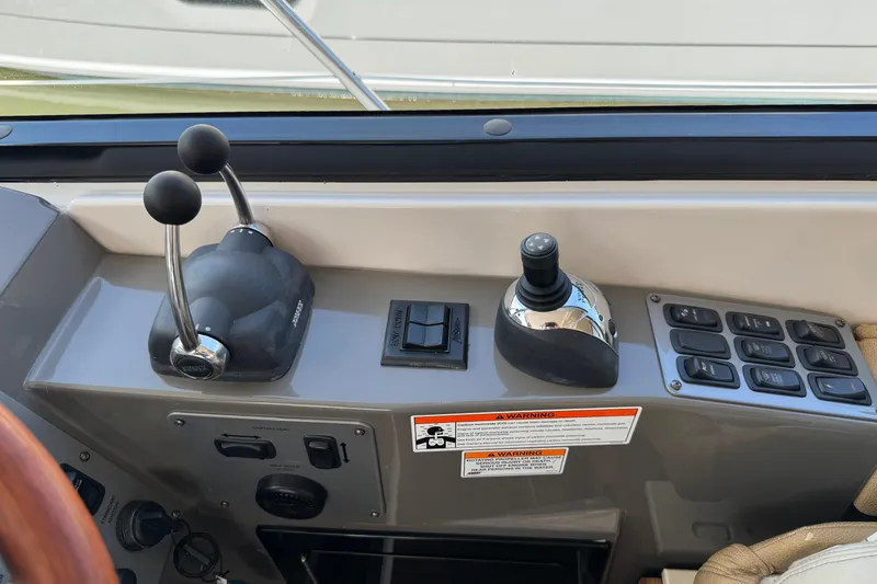 Slide: The Image of Control panel of a 2010 Regal 44 Sport Coupe boat with levers and switches. - 12