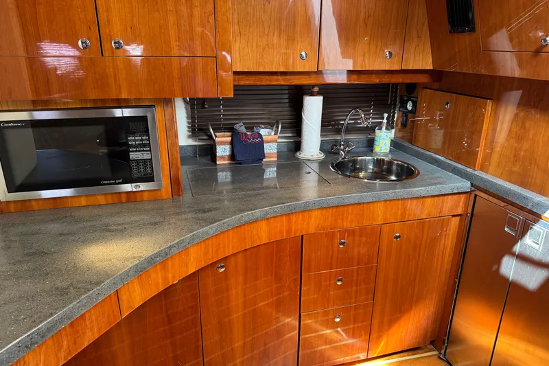 Slide: The Image of Luxurious 2010 Regal 44 Sport Coupe yacht kitchen with wood cabinetry and modern appliances. - 18