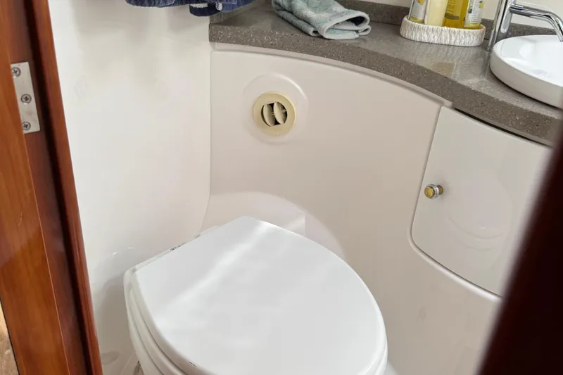 Slide: The Image of Bathroom interior of 2010 Regal 44 Sport Coupe yacht, featuring a compact toilet and countertop. - 24