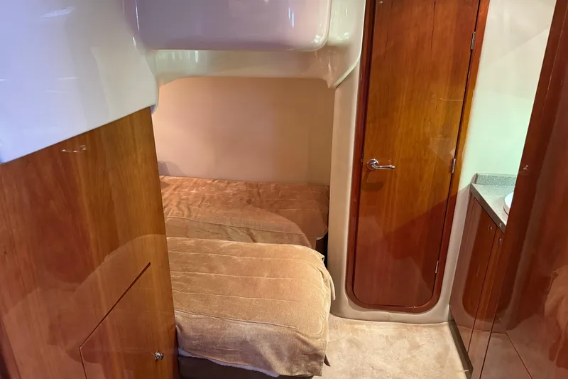 Slide: The Image of Interior cabin of 2010 Regal 44 Sport Coupe with twin beds and wooden finishes. - 27