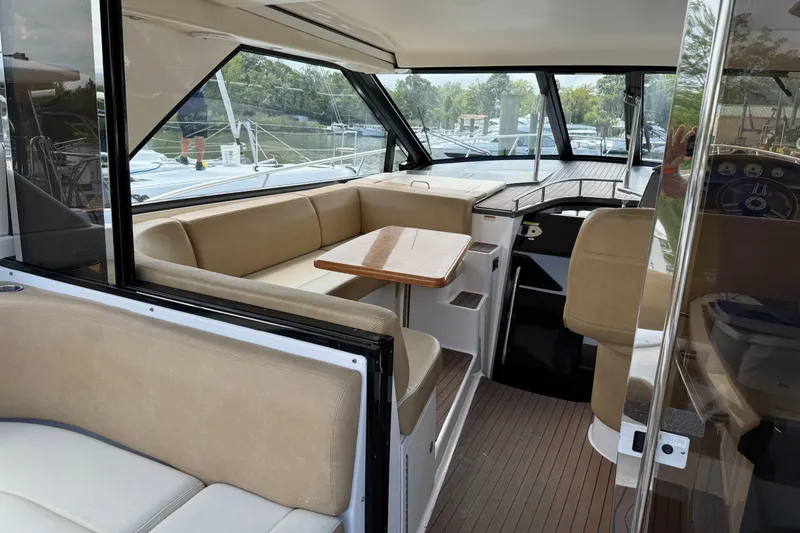 Slide: The Image of Interior of 2010 Regal 44 Sport Coupe yacht with beige seating and wooden table. - 6